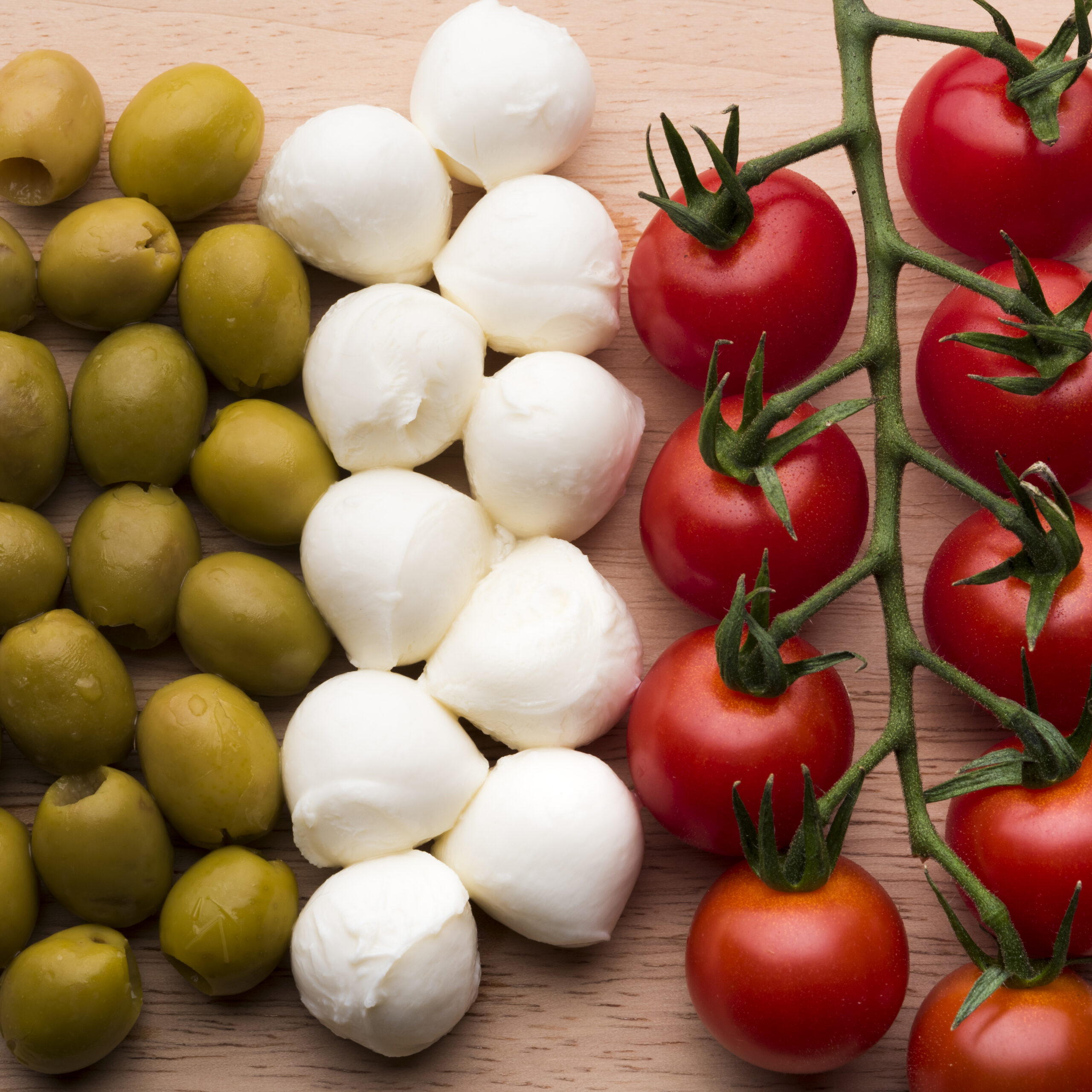 delicious-mozzarella-cheese-fresh-red-tomatoes-wet-olives-wooden-table-scaled.jpg
